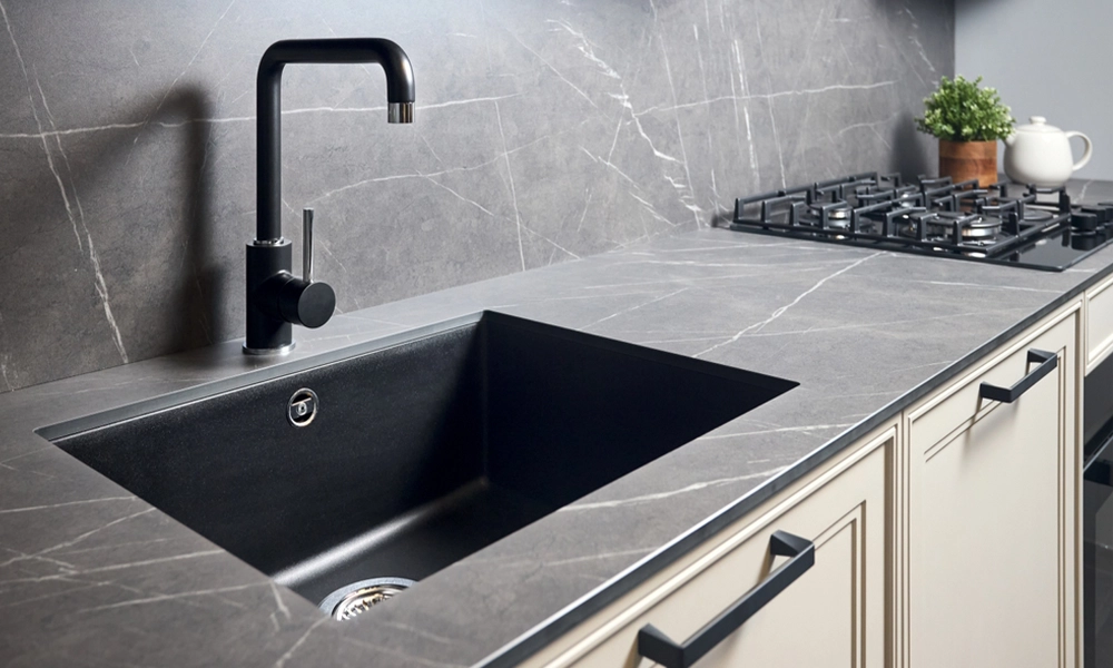 Modern kitchen with grey marble countertop and black sink, featuring sleek design and clean lines