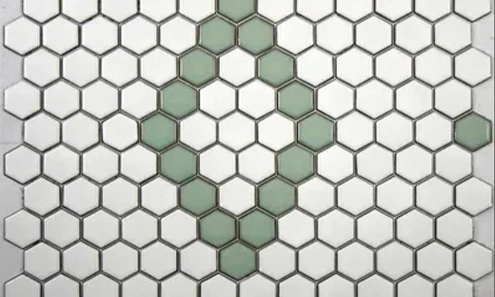 White hexagonal tiles with a few light green tiles scattered in a geometric pattern."