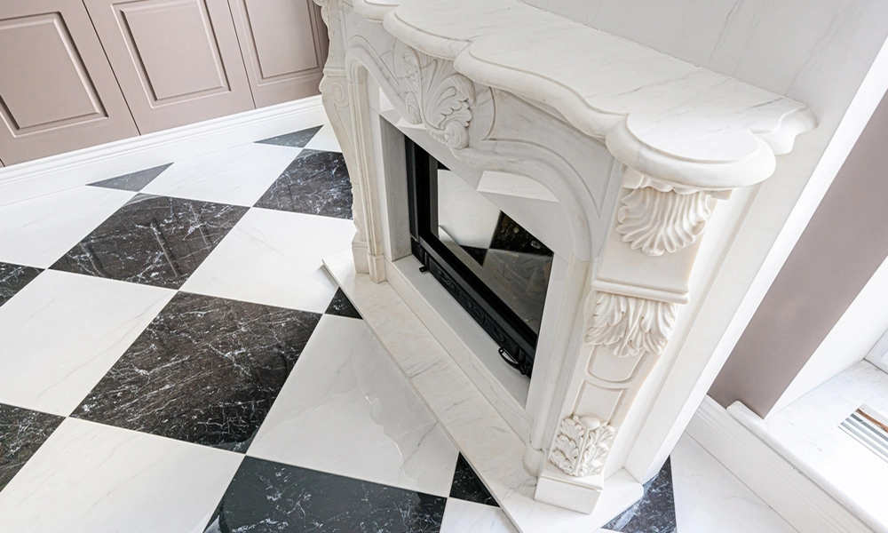 Luxury marble fireplace with detailed carvings, complemented by a black and white checkered marble floor